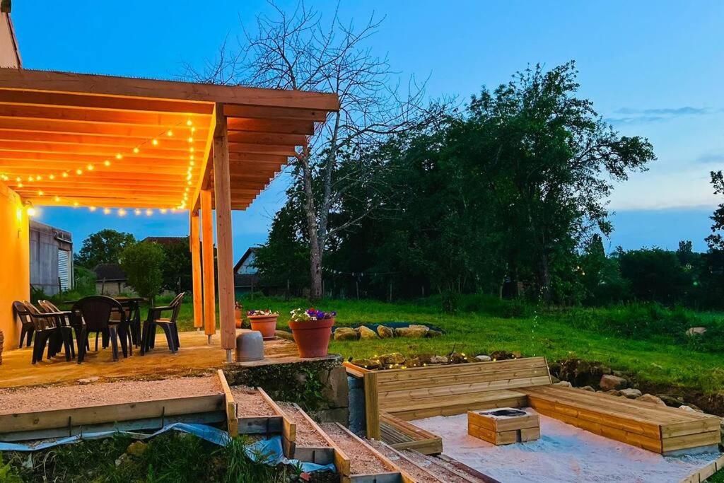 a backyard with a pergola and a table and chairs at Gîte l’Occitanette in Saint-Blancard