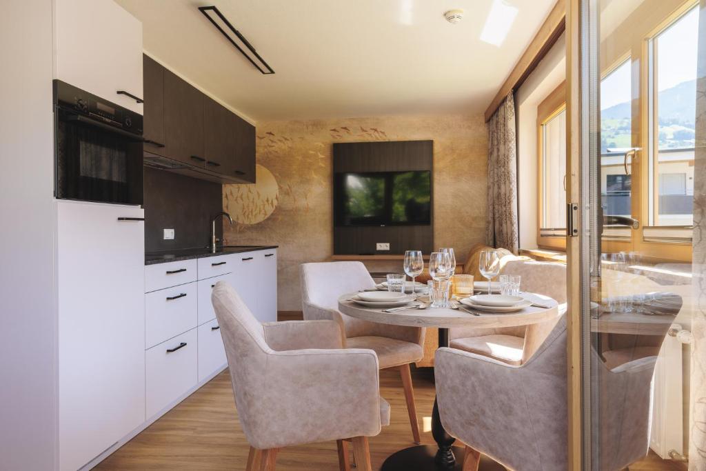 eine Küche und ein Esszimmer mit einem Tisch und Stühlen in der Unterkunft hin&weg das Aparthotel in Ried im Zillertal