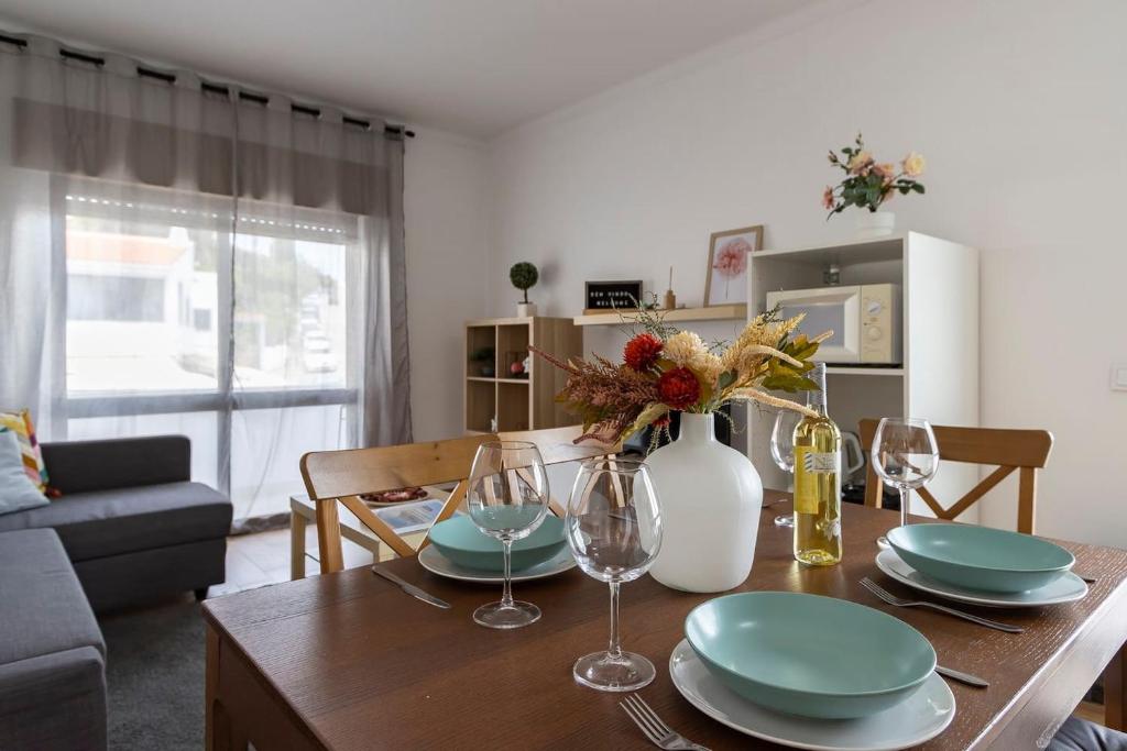 - une table à manger avec des assiettes et des verres à vin dans l'établissement Relaxing Beach Paradise, à Carvoeiro