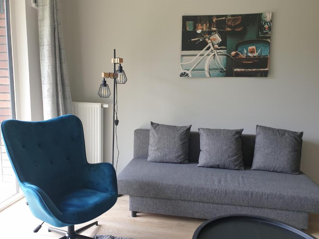 salon z kanapą i niebieskim krzesłem w obiekcie STARA CEGIELNIA, Faktura VAT, bezkontaktowe zameldowanie w Poznaniu