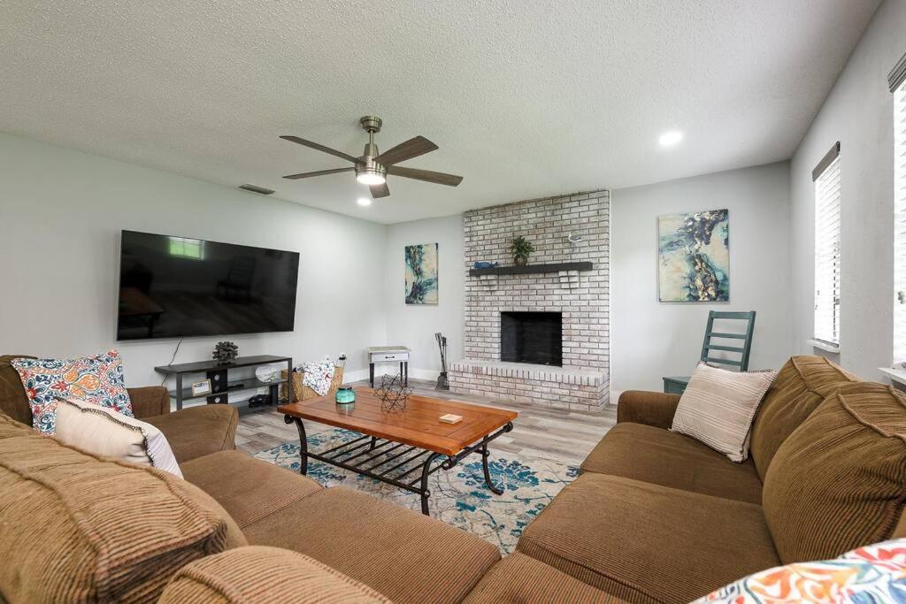 a living room with a couch and a fireplace at Daytona Buy! Mins from Beaches, Speedway, Airport in Daytona Beach