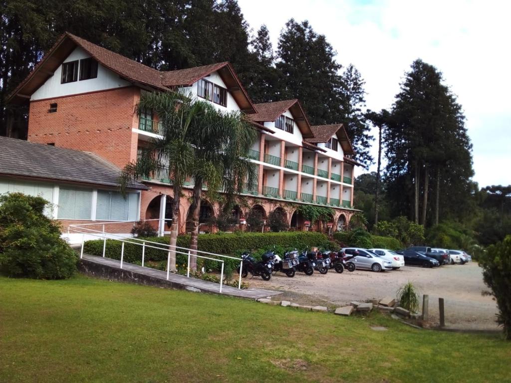 a large building with motorcycles parked in a parking lot at HOTEL CAMPO ALEGRE in Campo Alegre