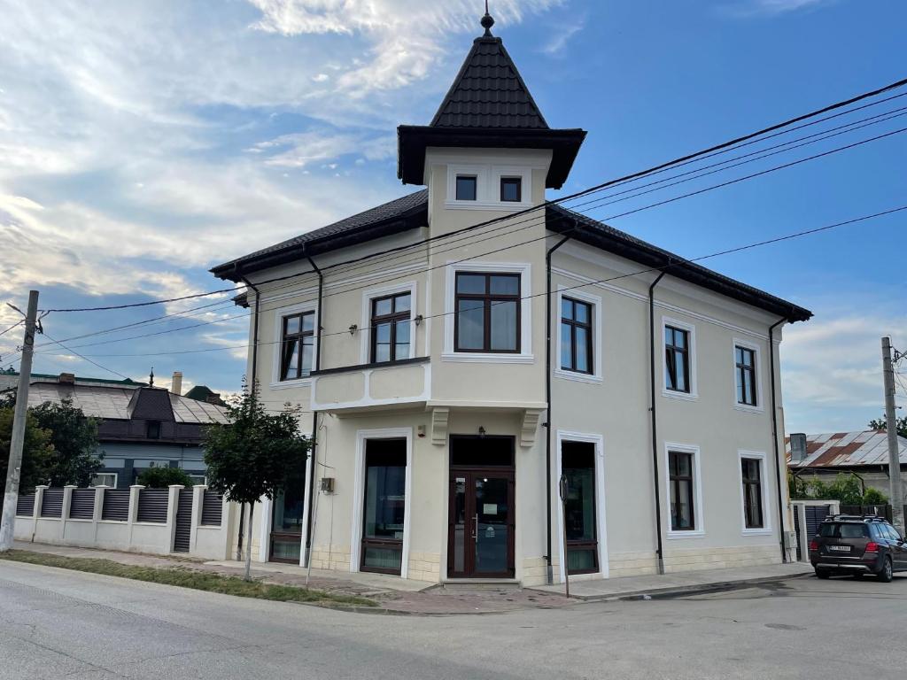 ein weißes Gebäude mit einem Turm darüber in der Unterkunft Racers' Home in Balş