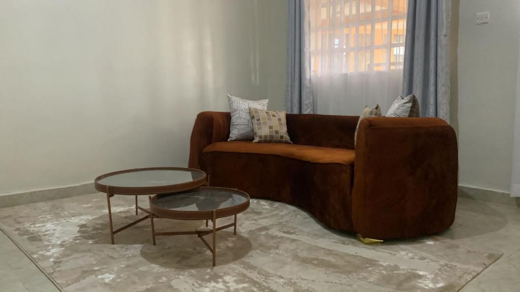 a living room with a brown couch and a table at Oak Nest in Kericho