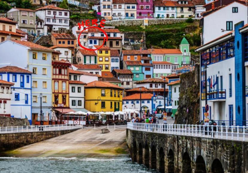 a view of a city with a bridge and buildings at Casa de pescadores con vistas al mar in Cudillero