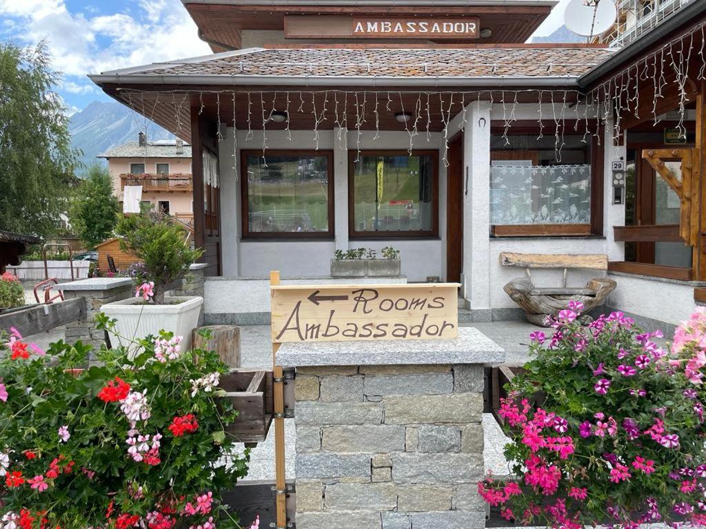 a sign on the front of a house with flowers at Ambassador Rooms in Bormio, SOLO CAMERA SENZA COLAZIONE in Bormio