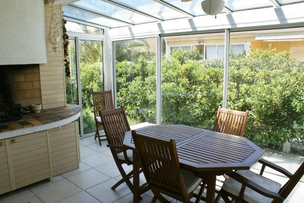 Il dispose d'une cuisine avec une table et des chaises. dans l'établissement Villa 17, Cap Sauvage au village naturiste, au Cap d'Agde