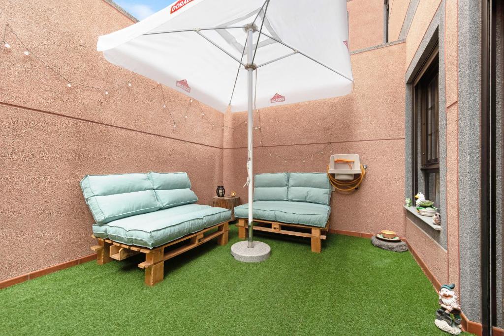 2 stoelen op een patio met parasol bij Brisa del Mar in Guía de Isora
