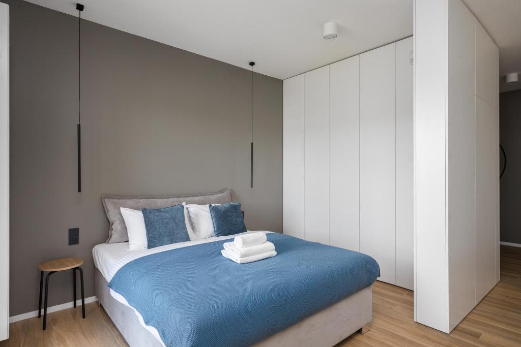 um quarto com uma cama grande e lençóis azuis em Okopowa Blue Apartment em Varsóvia