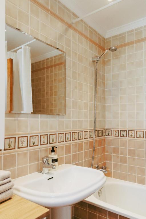 W łazience znajduje się umywalka, wanna i lustro. w obiekcie AP378 Casa Maria w mieście Nerja