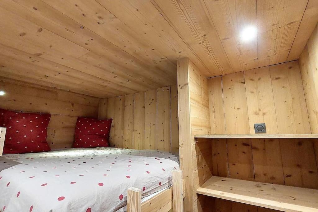 Zimmer mit einem Bett in einer Holzhütte in der Unterkunft Douillet 33 m² piscine et sauna - 6 pers in Huez