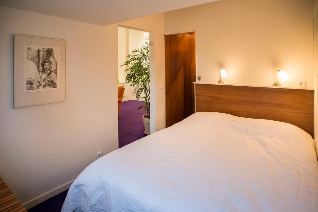 a bedroom with a large white bed in it at PetitGrandeur in Maastricht