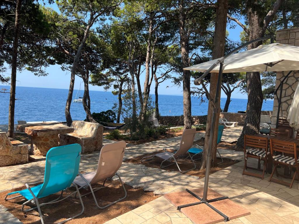 une terrasse avec des chaises et un parasol et l'océan dans l'établissement Apartman Zlatan, à Sveta Nedelja