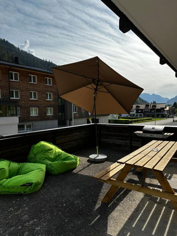 a picnic table and green bags on a roof with an umbrella at Haus St. Martin in Klösterle am Arlberg