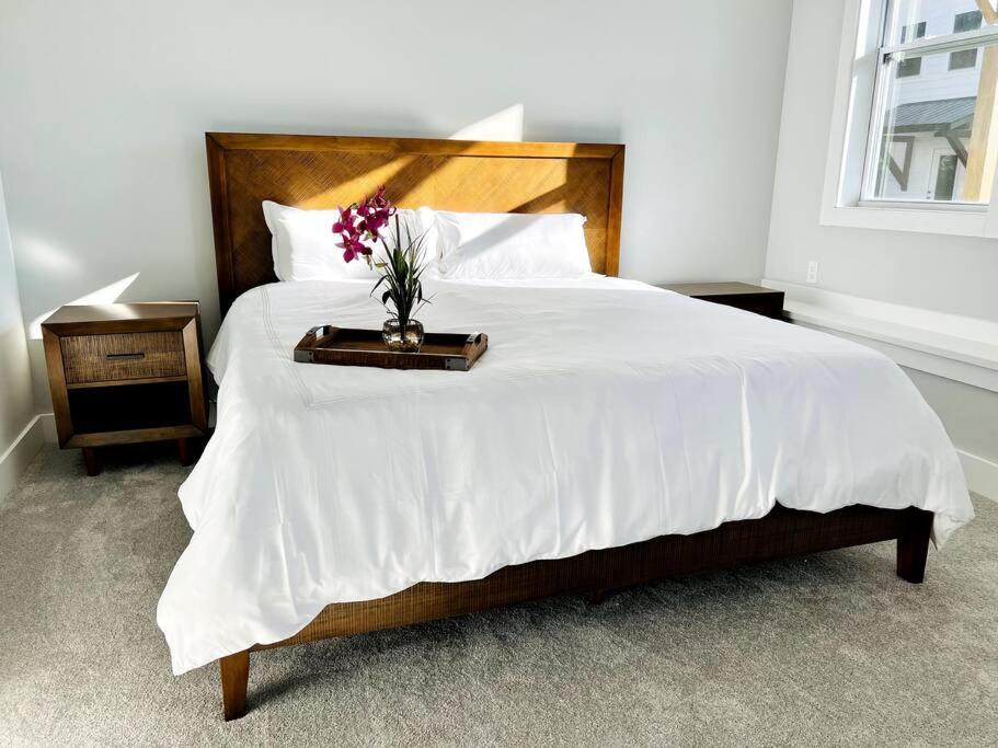 a bedroom with a large bed with a vase with flowers on it at French Broad Overlook in Asheville