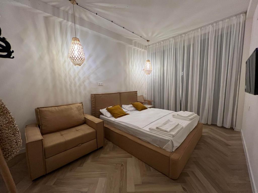 1 dormitorio con 1 cama y 1 silla en LIMANI, en Grigoleti
