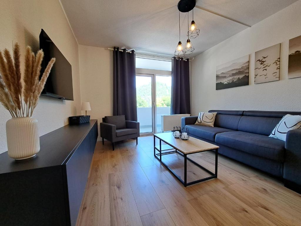 a living room with a blue couch and a table at Harz-Glück-Fewo in Bad Harzburg