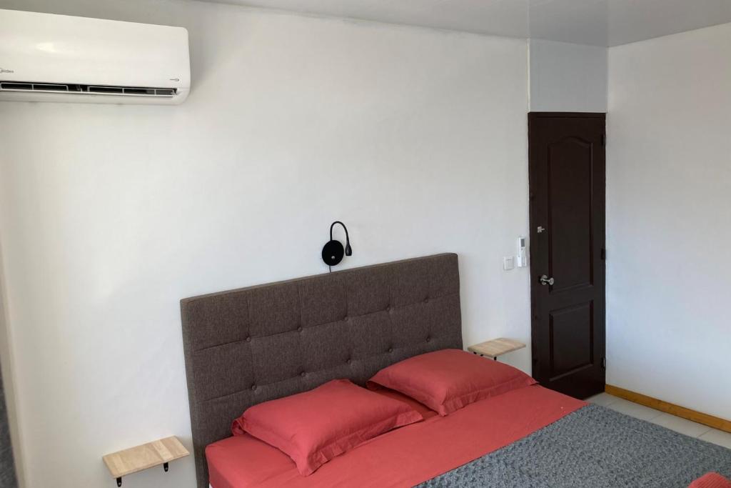 - une chambre avec un lit doté d'oreillers rouges dans l'établissement "Tiaré" city center room, à Papeete