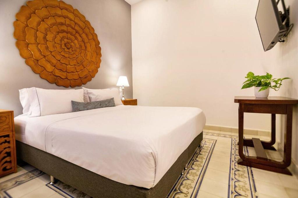 a bedroom with a large white bed and a table at L1-cm Loft Apartment In Getsemani With Air Conditioning Pool And WIFI in Cartagena de Indias