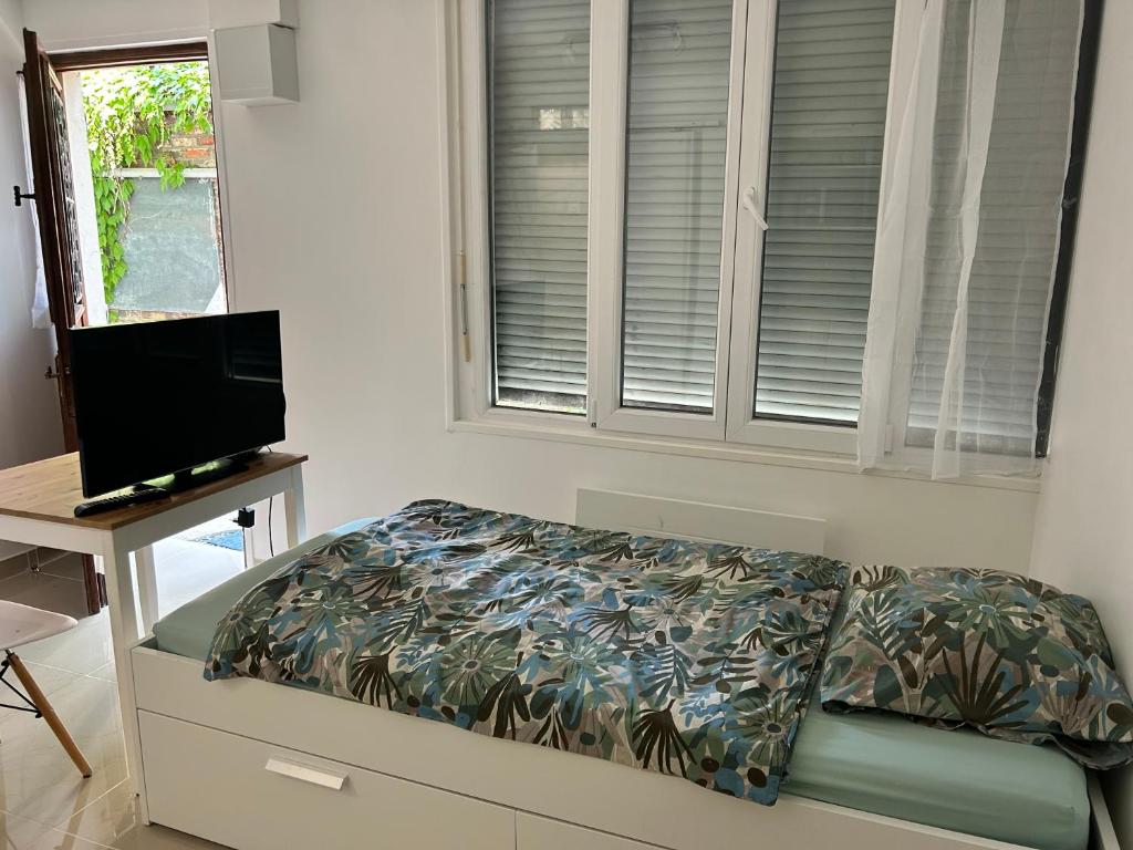 a bedroom with a bed and a television and a window at Studio3 Centre ville Massy in Massy