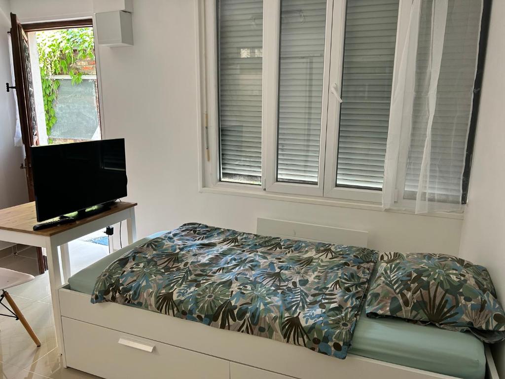 une chambre avec un lit, une télévision et une fenêtre dans l'établissement Studio3 Centre ville Massy, à Massy