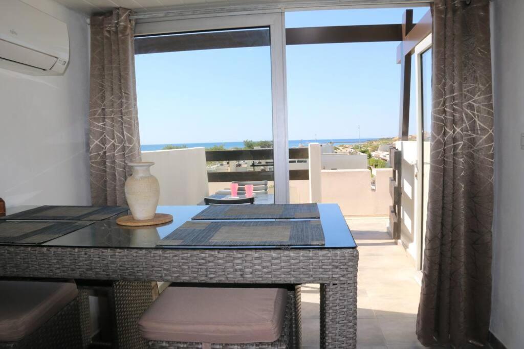 une salle à manger avec une table et une grande fenêtre dans l'établissement Studio 74, Port Nature 2 au village naturiste, au Cap d'Agde