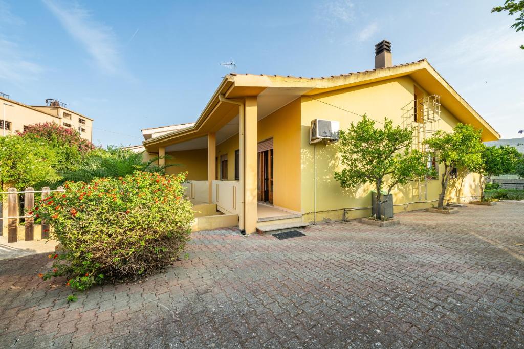 a small yellow house with a brick driveway at Casa Vacanze San Giovanni in San Giovanni Suergiu