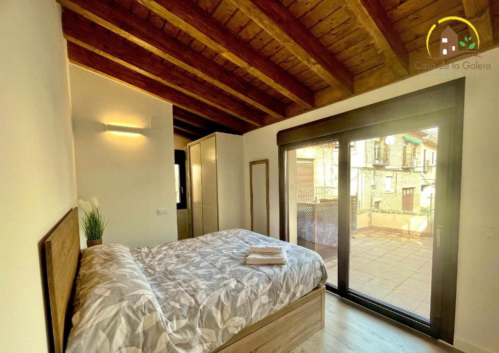 een slaapkamer met een bed en een glazen schuifdeur bij Casa de la Galera Alojamiento Turístico en Toledo in Toledo