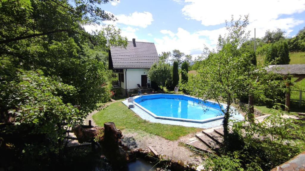a swimming pool in the yard of a house at Apartman Mitrić in Šipovo