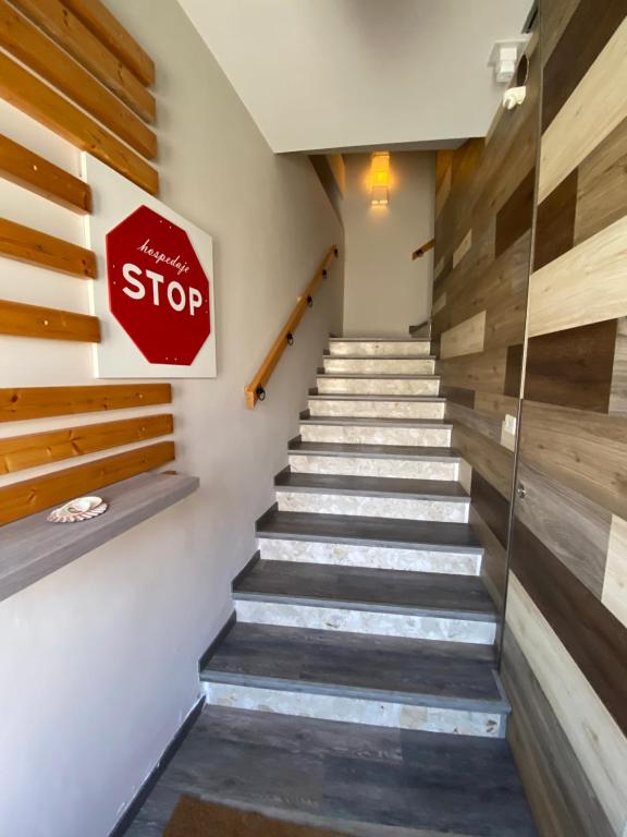 un panneau d'arrêt sur un mur à côté d'un escalier dans l'établissement HOSPEDAJE STOP, à Corrubedo