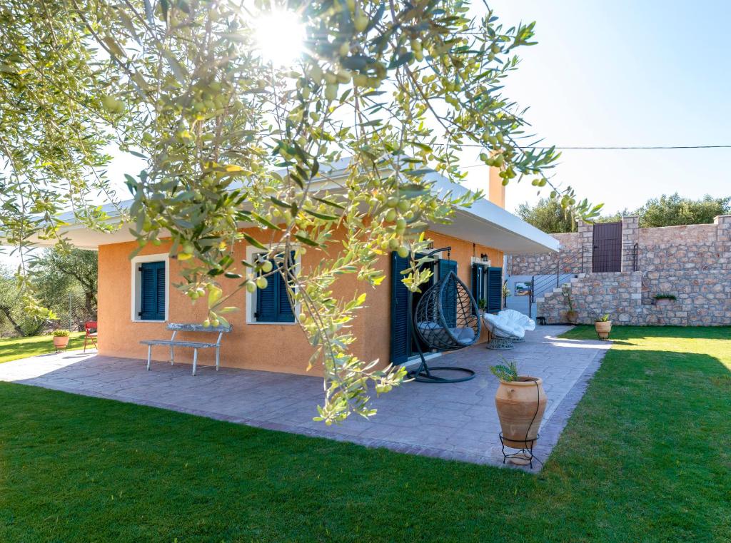 a house with a yard with a patio at Villa Amerita in Elia Laconias