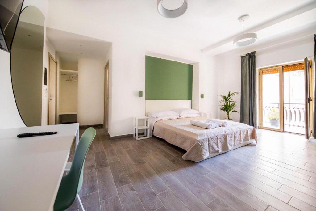 una camera con letto e parete verde di Akheilos a Soverato Marina