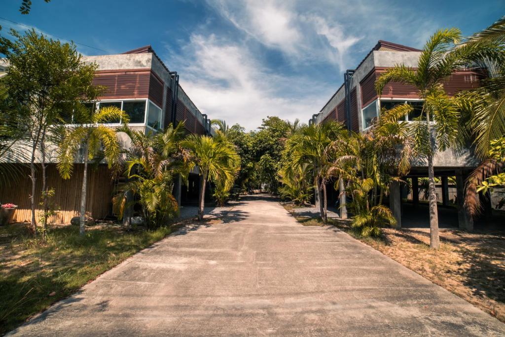 an empty street with palm trees in front of a building at Green Mango in Thong Sala