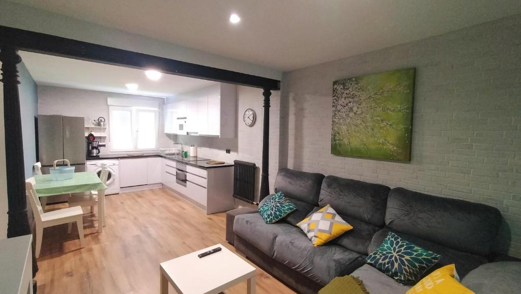 ein Wohnzimmer mit einem Sofa und einer Küche in der Unterkunft Zona tranquila, cerca del Casco Antiguo. EBI02480 in Bilbao
