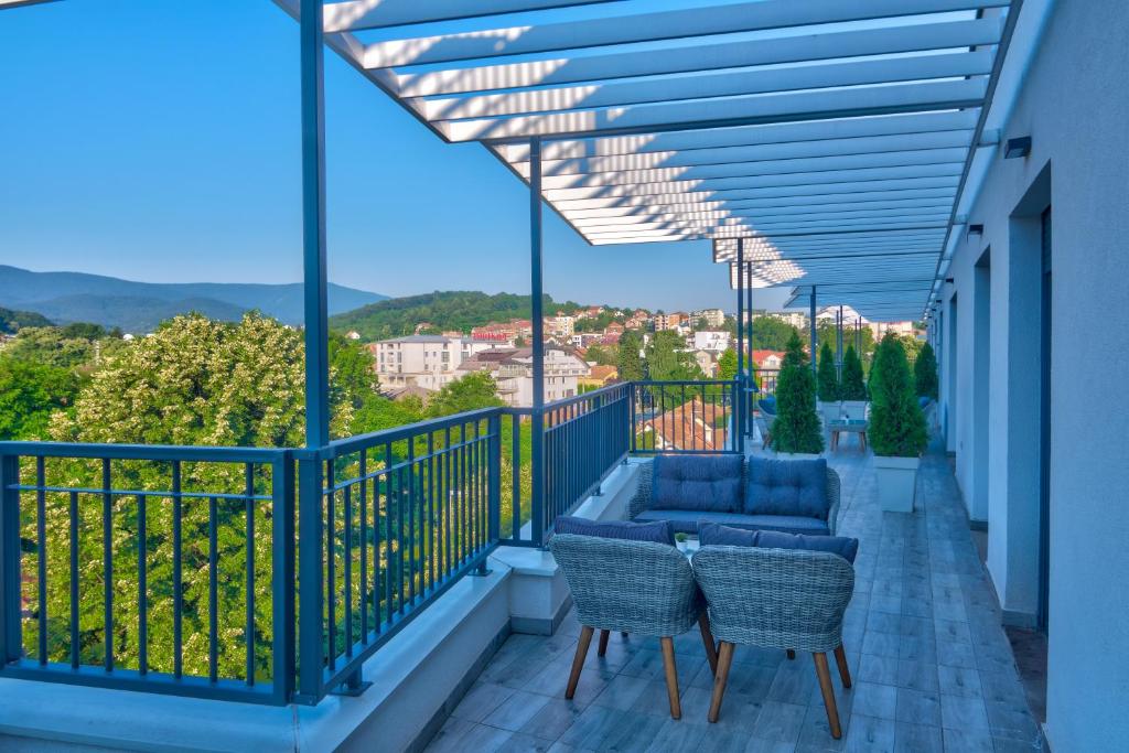 a balcony with chairs and a view of a city at Vision apartmani Vrnjačka Banja in Vrnjci
