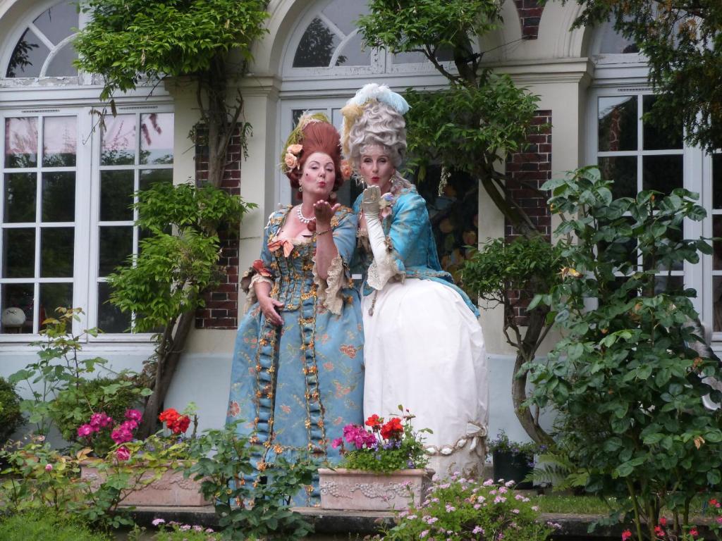 a statue of two women standing in a garden at L&#39;Orangerie White-Palacio in Versailles