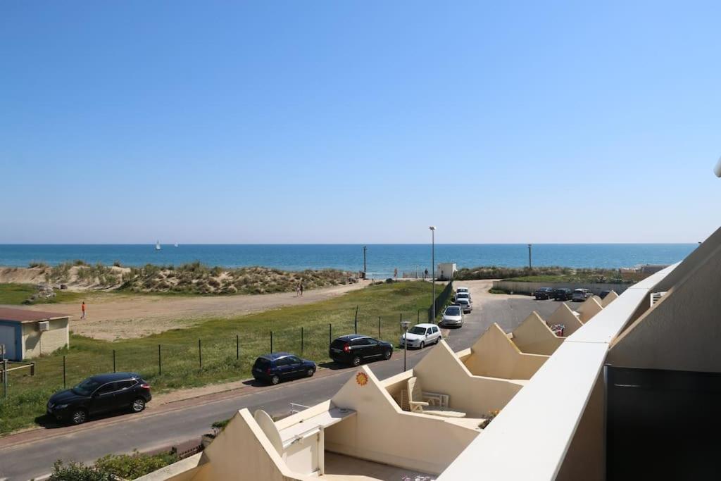 - une vue sur une route avec des voitures garées sur la plage dans l'établissement Studio 232, Héliopolis AB au village naturiste, au Cap d'Agde