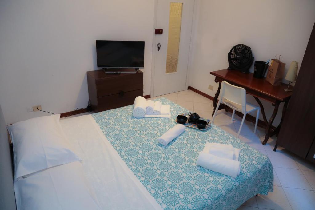 um quarto com uma cama, uma secretária e uma televisão em Guest House Malaguzzi em Reggio Emilia