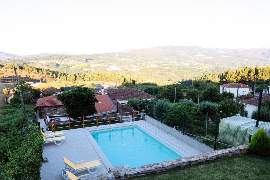 uma imagem de uma piscina numa casa em Casa do avô tamanqueiro em Arco de Baúlhe