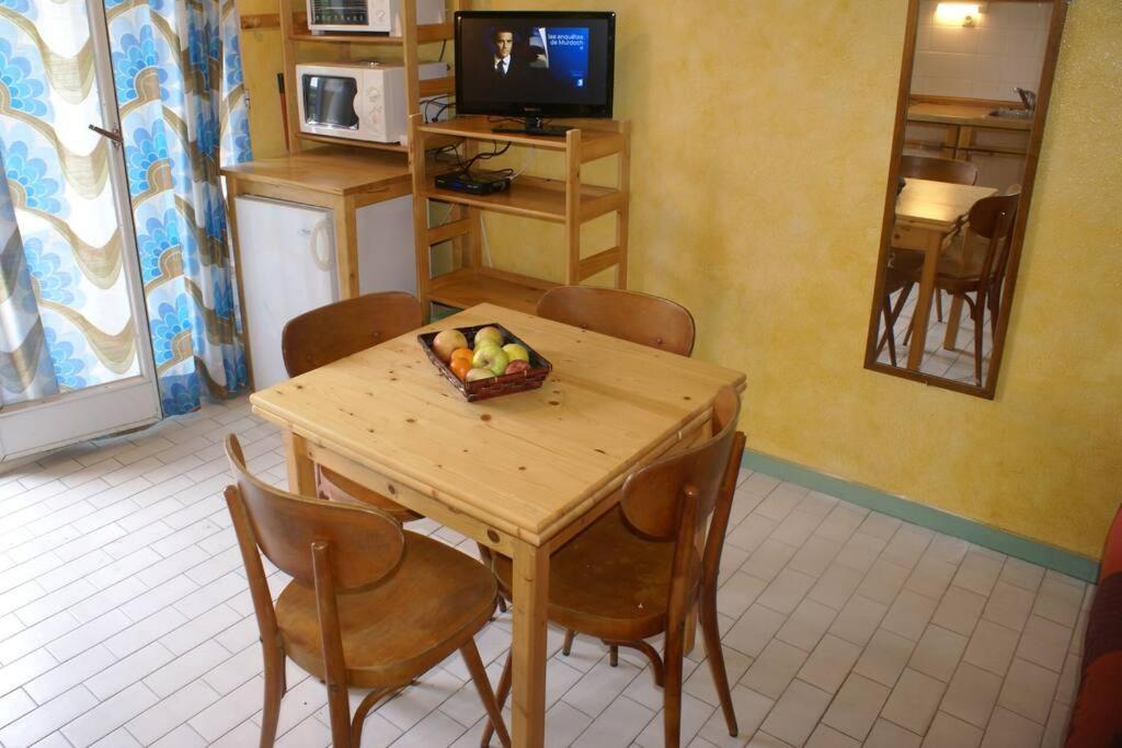 - une table et des chaises avec un bol de fruits dans l'établissement Villa 12, Port Vénus au village naturiste, au Cap d'Agde