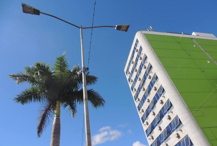 um edifício e uma palmeira e uma luz de rua em Hotel Estação Norte - Fácil acesso ao Imbel e o distrito industrial e colégio Militar - By Up Hotel em Juiz de Fora