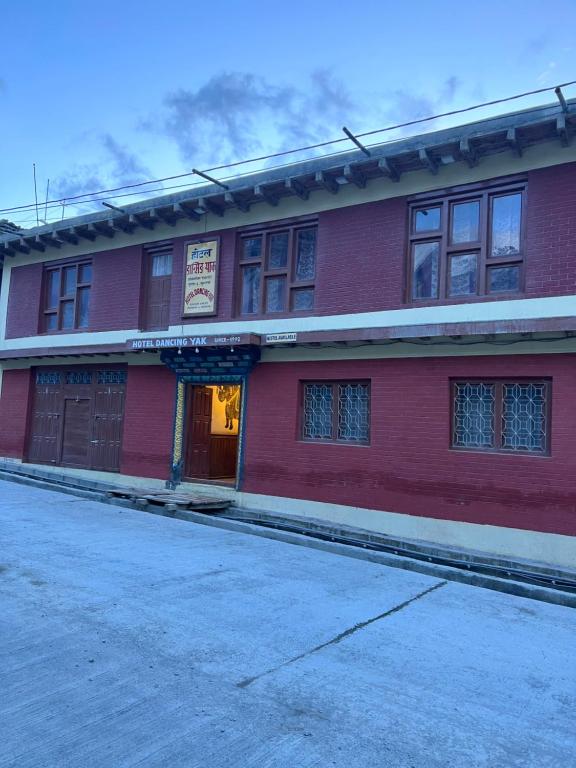 ein rotes Backsteingebäude mit einem Schild darauf in der Unterkunft Hotel Dancing Yak in Jomsom