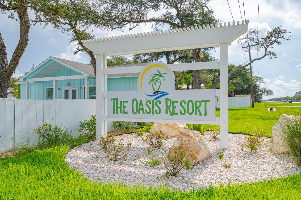 um sinal para o resort de classe em frente a uma casa em The Oasis Resort em Rockport