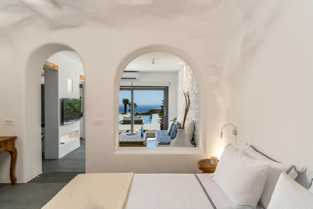 a bedroom with a bed and a view of the ocean at Numa Santorini in Fira