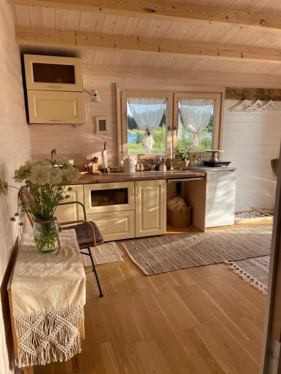 una cocina con armarios blancos y una mesa en una habitación en Ambercoast en Jūrmala