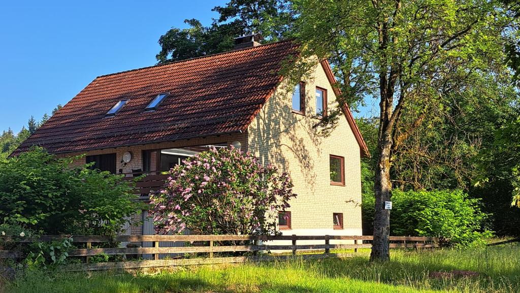 ein Haus mit einem Holzzaun davor in der Unterkunft Ferienwohnungen Haus am Karpfenteich in Hahnenklee-Bockswiese