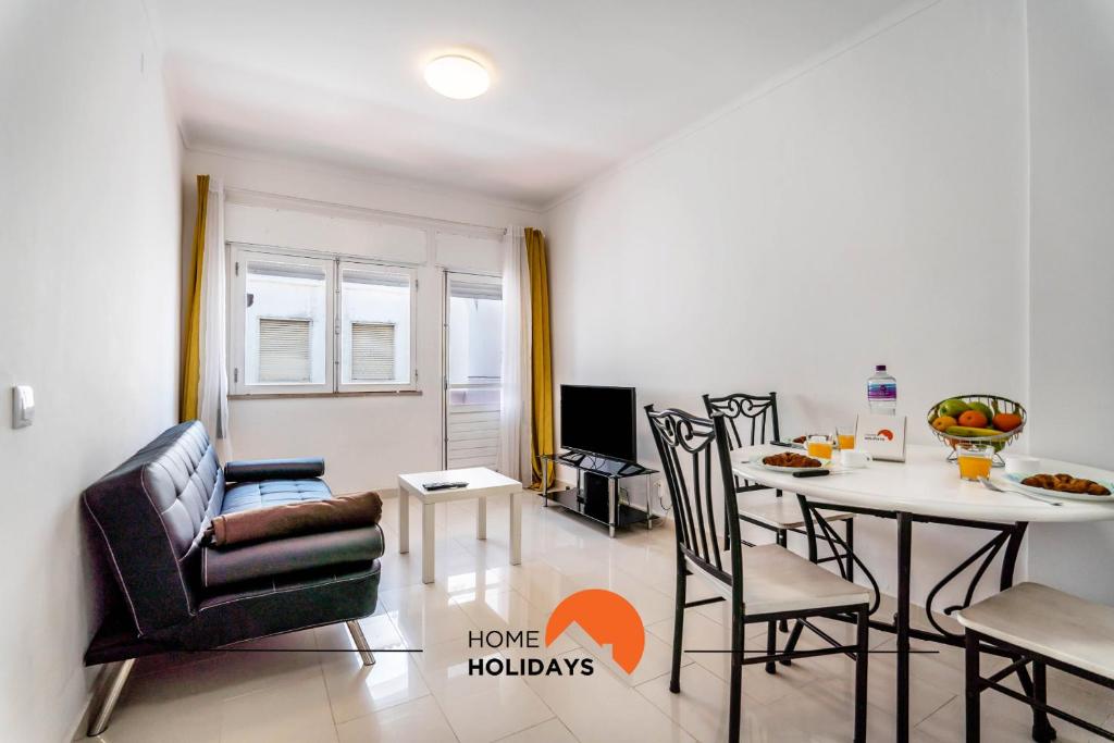 ein Wohnzimmer mit einem Tisch und Stühlen sowie eine Küche in der Unterkunft #162 Old Town Open Space with Balcony 120 mts Beach in Albufeira