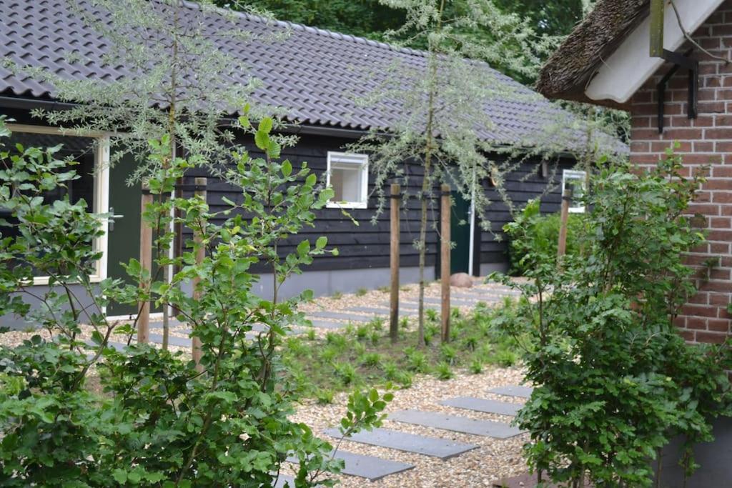 einen Garten vor einem Haus mit Bäumen in der Unterkunft Essenereng in Kootwijkerbroek