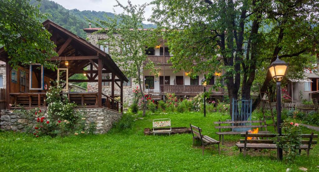 a park with benches and a building in the background at Villa Mestia Hotel in Mestia