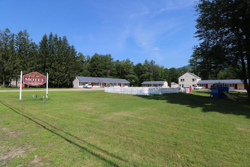 a large grass field with a sign in front of a building at The Villager Motel in Bartlett
